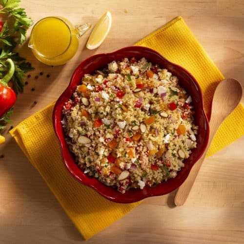 A red bowl full of couscous salad