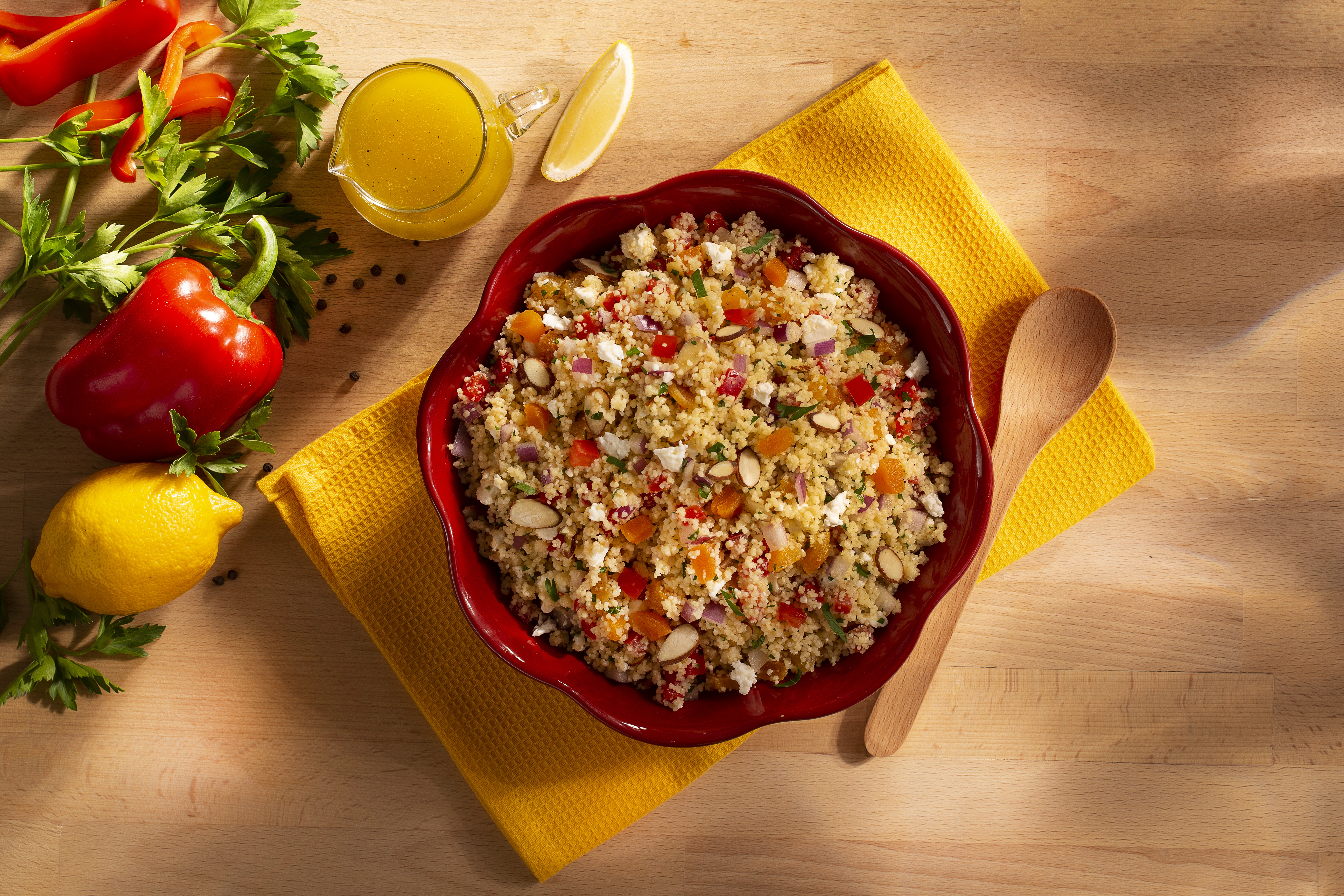 A red bowl full of couscous salad