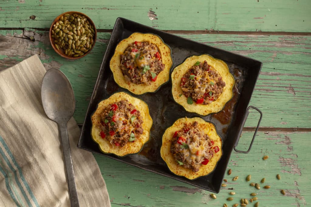 Stuffed Acorn Squash in a metal dish a green board