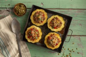 Stuffed Acorn Squash in a metal dish a green board