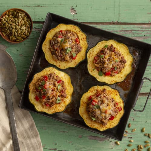 Stuffed Acorn Squash in a metal dish a green board