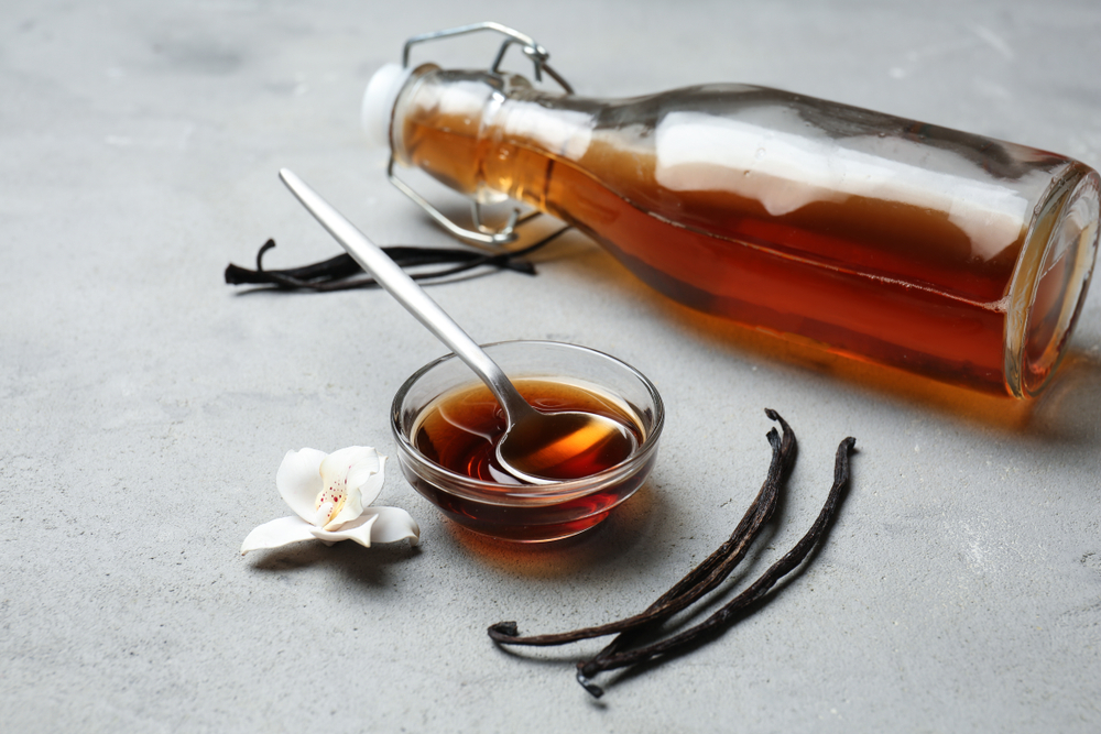 Homemade Vanilla Extract with vanilla beans on a cement counter