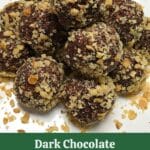 A platter of dark chocolate balls covered in chopped walnuts
