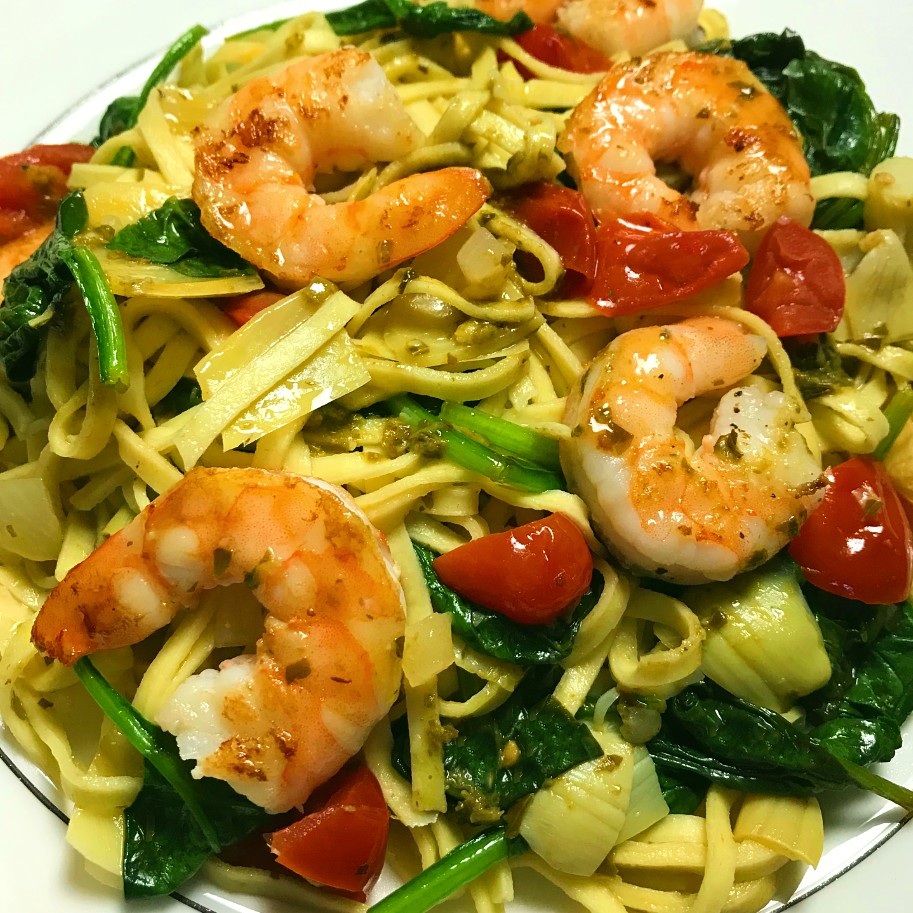 Shrimp with fresh vegetables and pesto served over pasta