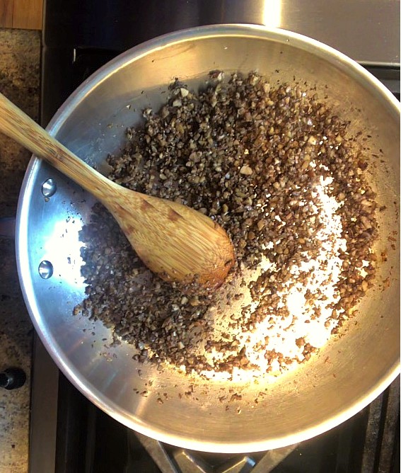 Cooked chopped mushrooms in a frying pan.   