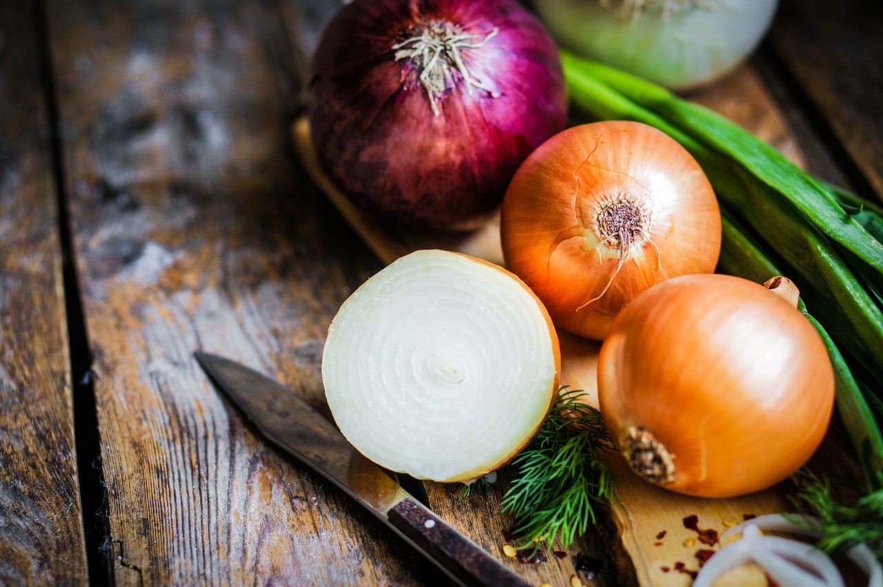 A cutting board of various onion varieties