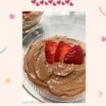 Dark Chocolate Orange mousse in a fancy glass dish on a marble counter top. The mousse has 3 sliced strawberries on top for a festive Valentine's day look.