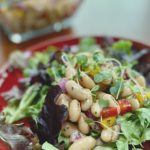 A plate of lettuce topped with an Italian Bean Salad