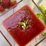 A glass bowl of strawberry gazpacho soup