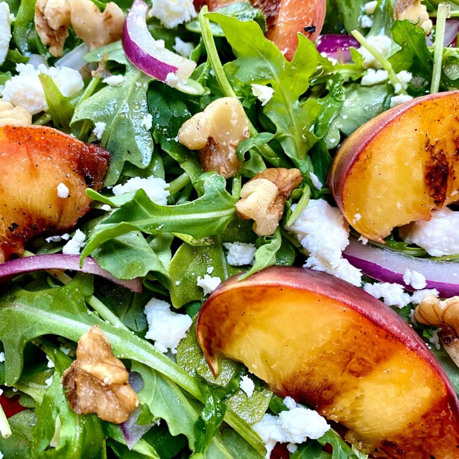 Arugula salad topped with grilled peaches