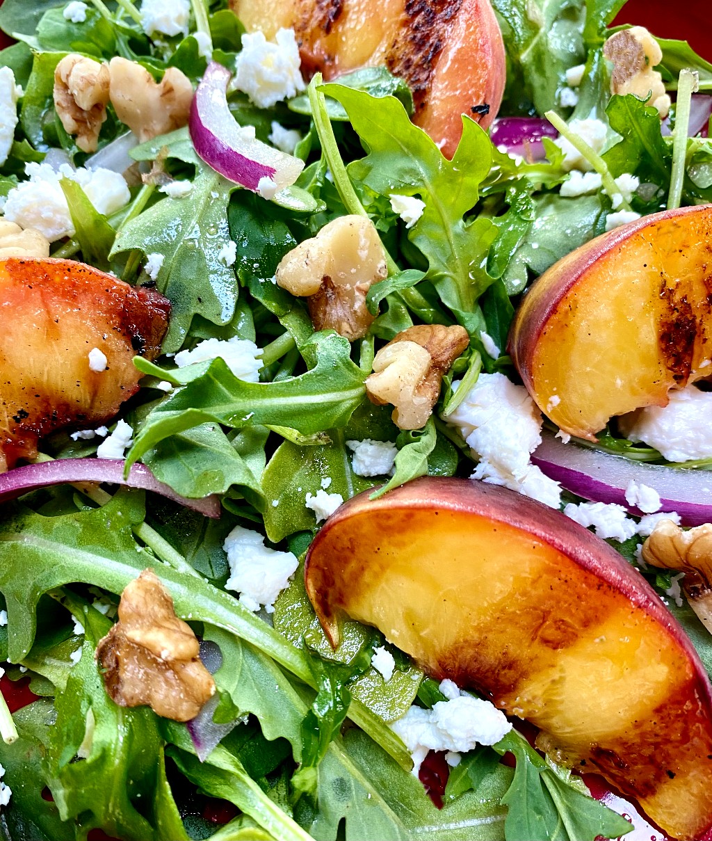 Arugula salad topped with grilled peaches