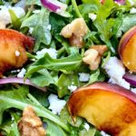 Arugula salad topped with grilled peaches