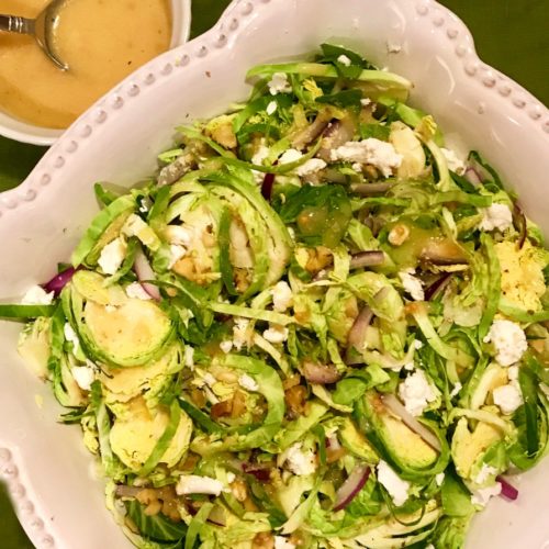 Shaved Brussel Sprout Salad in a white serving bowl.