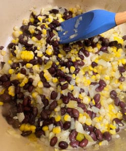 Sauteing beans and corn in a large stock pot for soup
