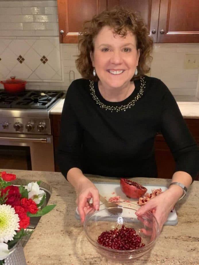 Laura M. Ali, RD holding a bowl of pomegranate seeds