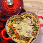 A heart shaped dish with a penne pasta and tomato casserole