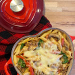 A heart shaped dish with a penne pasta and tomato casserole