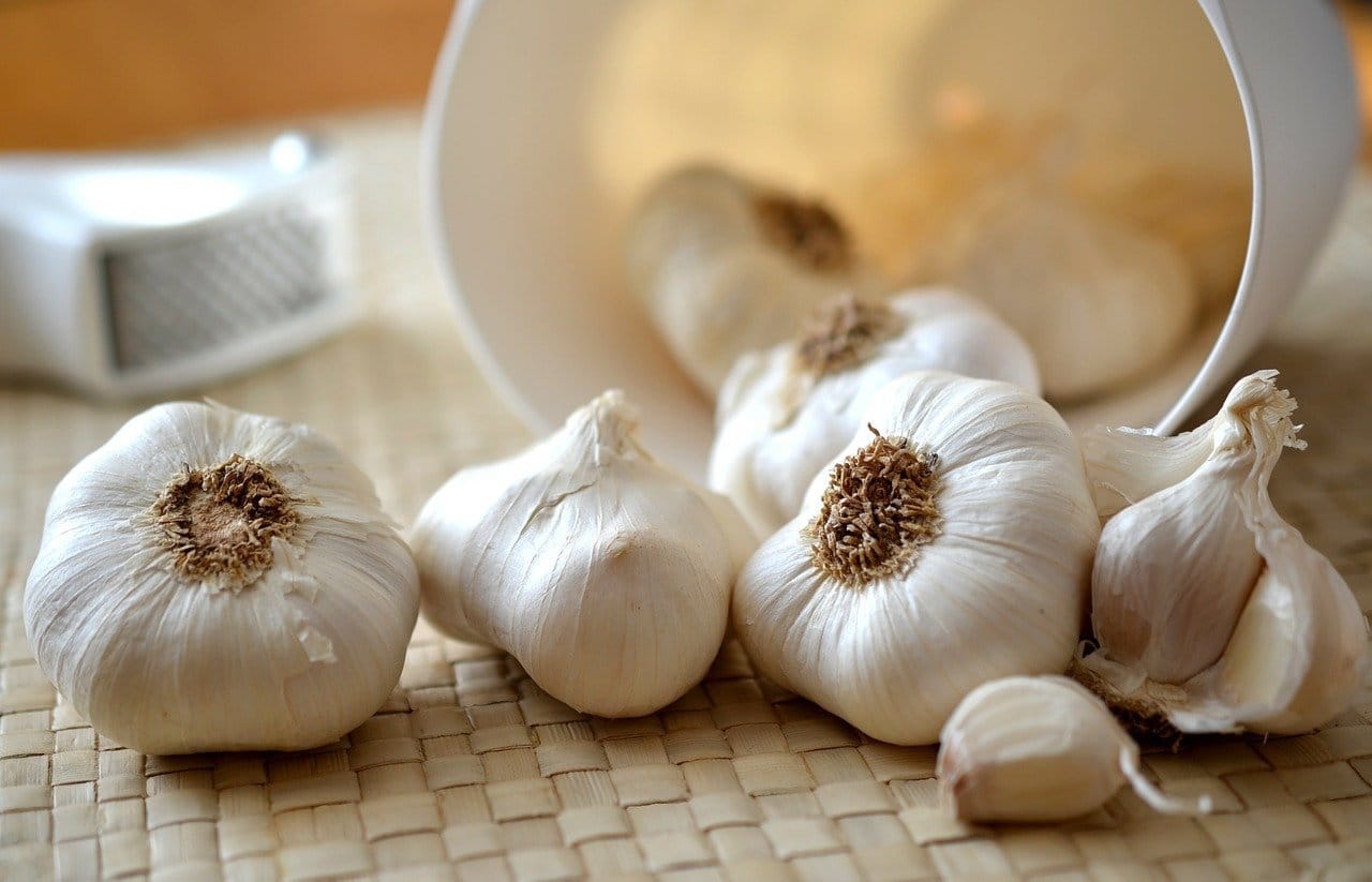 Garlic bulbs and cloves on a woven mat
