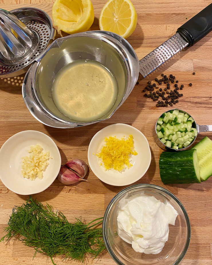Ingredients to make a dill sauce of salmon on a cutting board