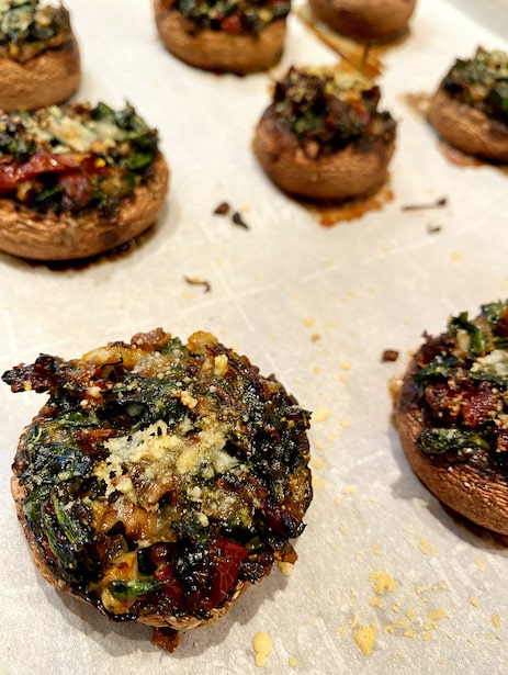 Stuffed mushrooms on a baking sheet after baking.