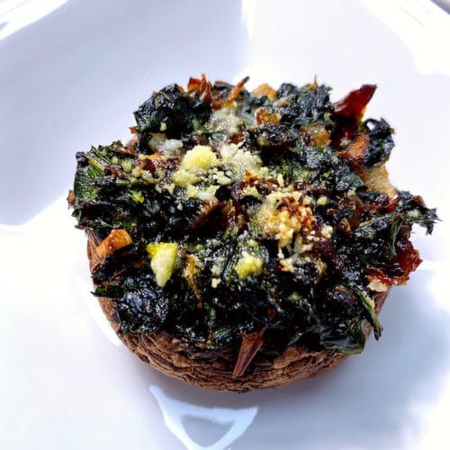 A plate with one spinach stuffed mushroom