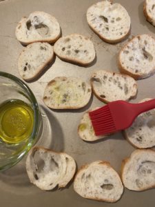 Brushing crostini with olive oil with a silicon brush