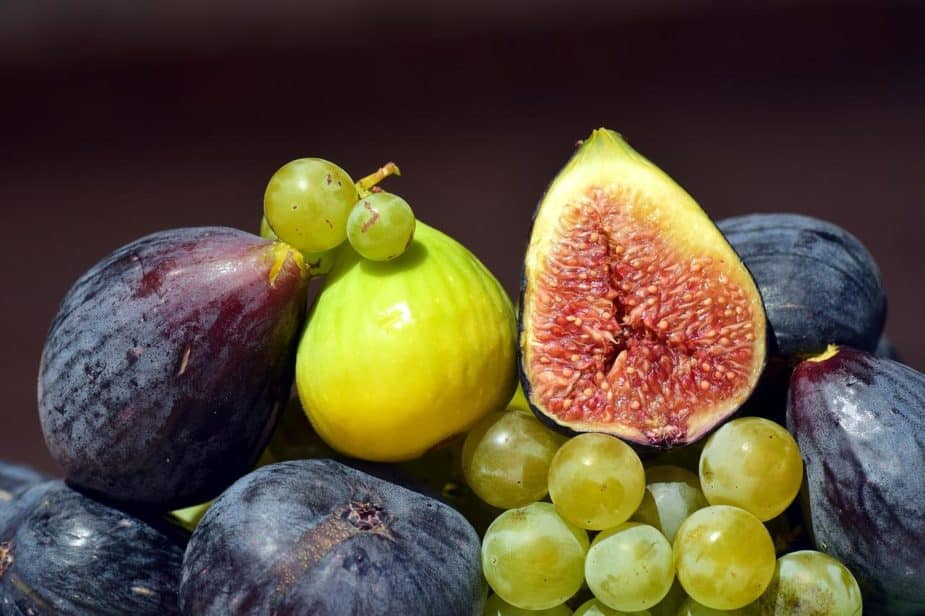 A bowl of fresh figs and some grapes