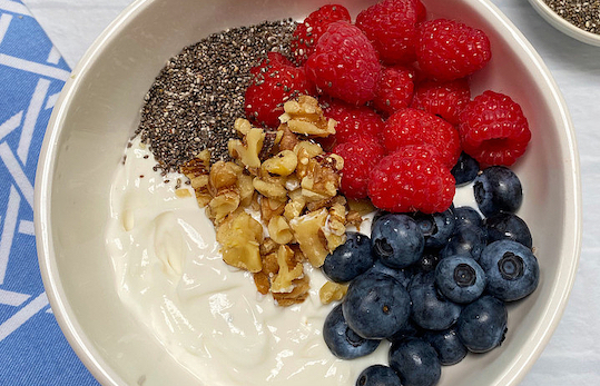 Plain yogurt topped with berries and walnuts