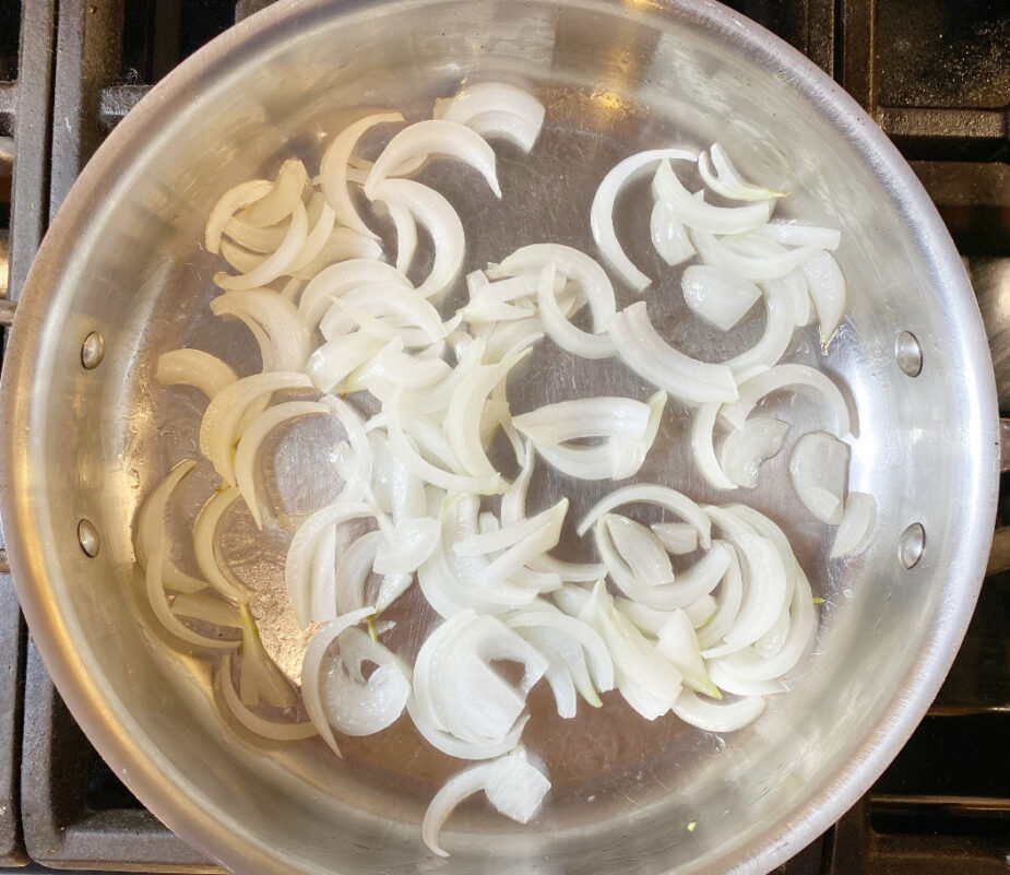 a saute pan full of slices of sweet onions