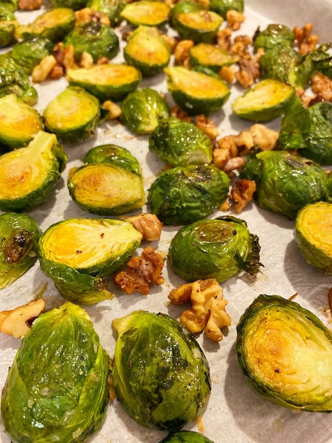 Roasted Brussel Sprouts and walnuts on a parchment lined sheet pan