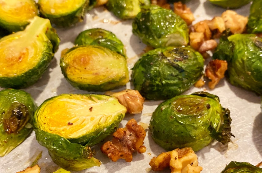 Roasted Maple Balsamic Brussel Sprouts on a parchment lined sheet pan