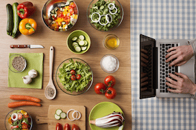 Wooden table with ingredients and laptop