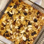 An 8x8 glass baking pan with baked oatmeal filled with dried cherries, almonds and dark chocolate chips