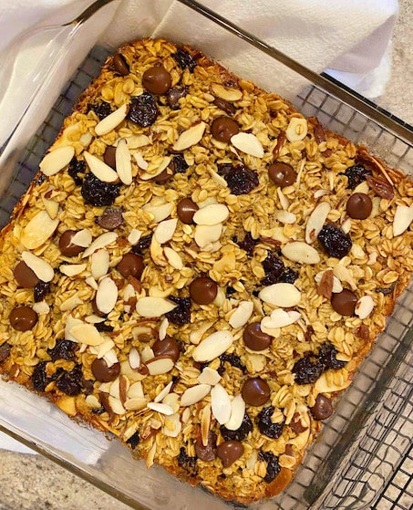 An 8x8 glass baking pan with baked oatmeal filled with dried cherries, almonds and dark chocolate chips