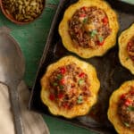 Stuffed Acorn Squash in a metal dish a green board