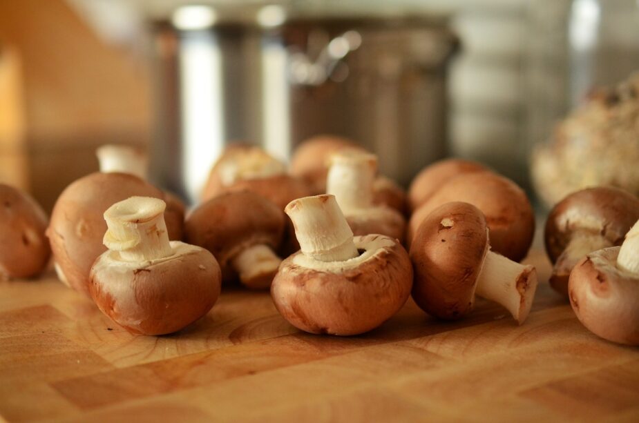 Cremini (baby bella) mushrooms on a wooden cutting  board