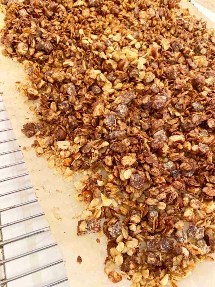 Dark Chocolate Hazelnut Granola on a piece of parchment paper on top of a wire rack.