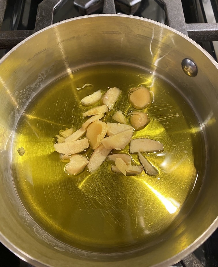Ginger in a saucepan with olive oil cooking over low heat