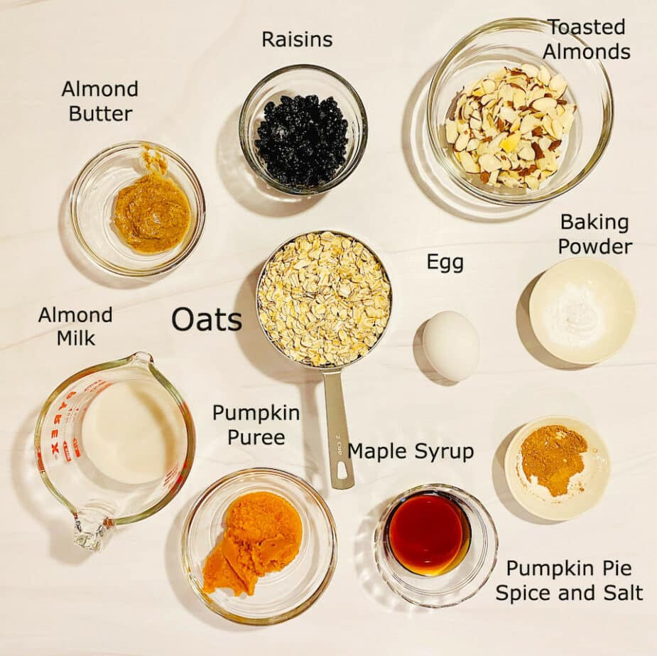 The ingredients measured out to use to make baked pumpkin oat bars on a marble counter top. 