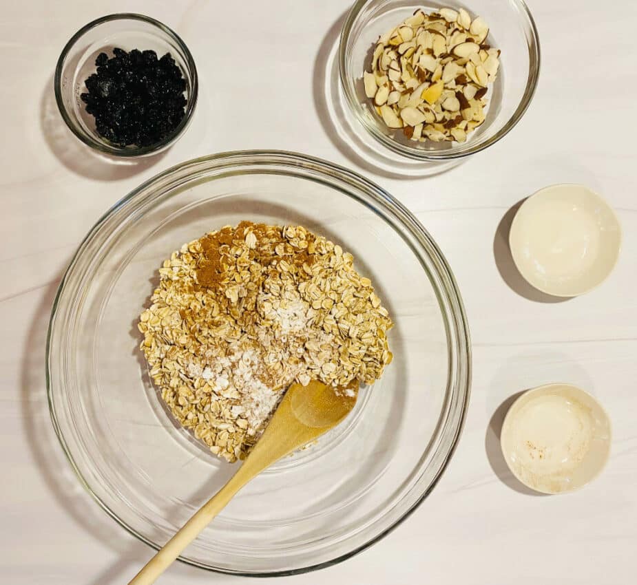 Dry ingredients going into a large bowl for baked pumpkin oat bars.