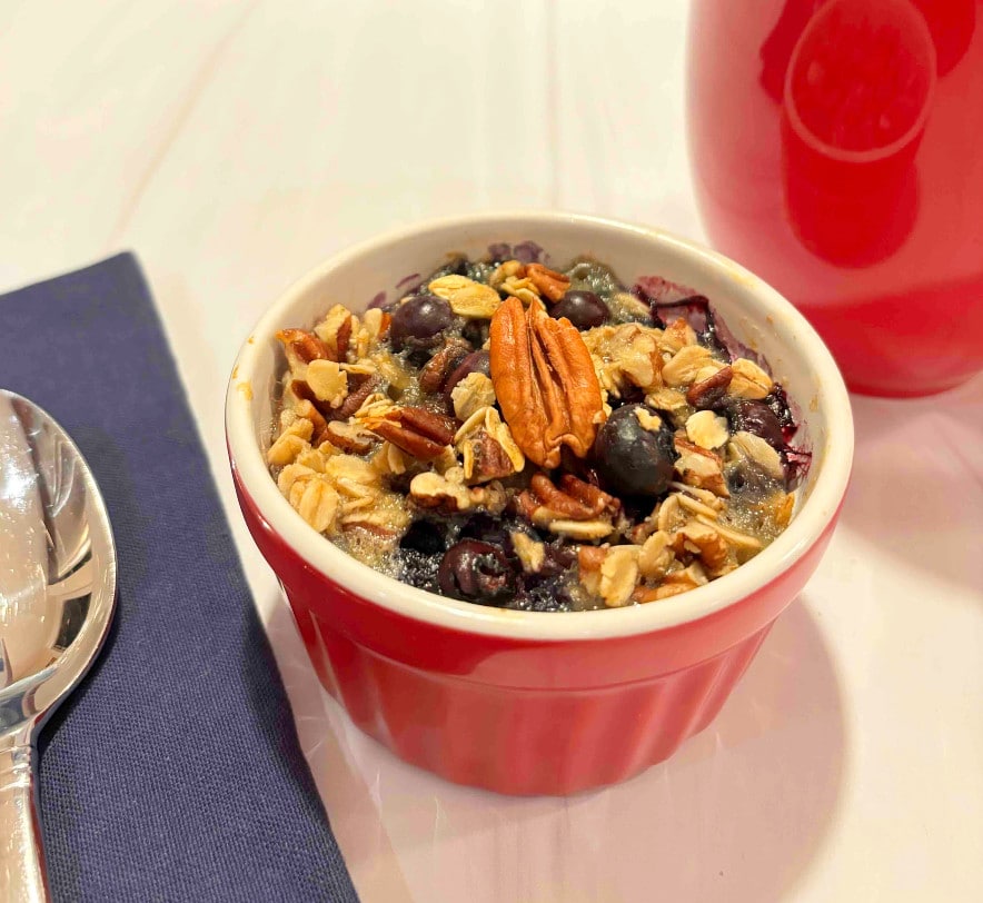 Baked oats with coffee A blueberry baked oat cup with a cup of coffee on the side.