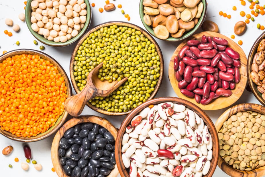 A counter filled with bowls of dried beans and peas