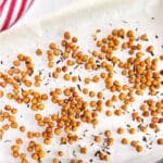 A parchment lined sheet pan filled with roasted chickpeas fresh from the oven
