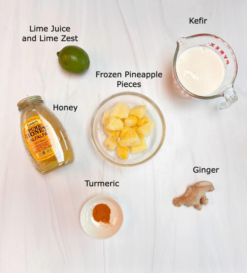 Ingredients to make a pineapple ginger smoothies on a marble counter