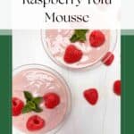 2 decorative glass cups filled with raspberry lime tofu mousse on a white counter surrounded by fresh raspberries