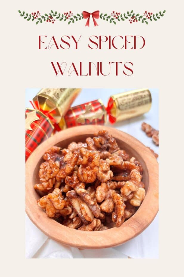 Spiced walnuts in a wooden bowl with holiday treats in the background