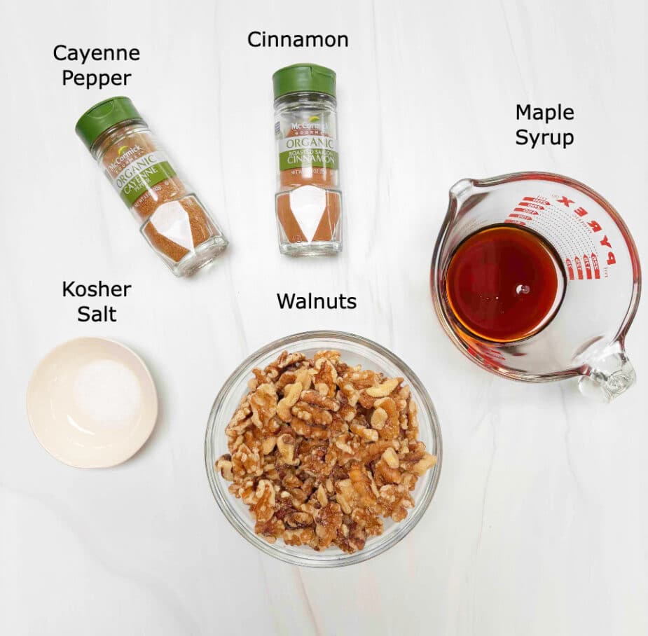 Ingredients to make spiced walnuts on a white counter top