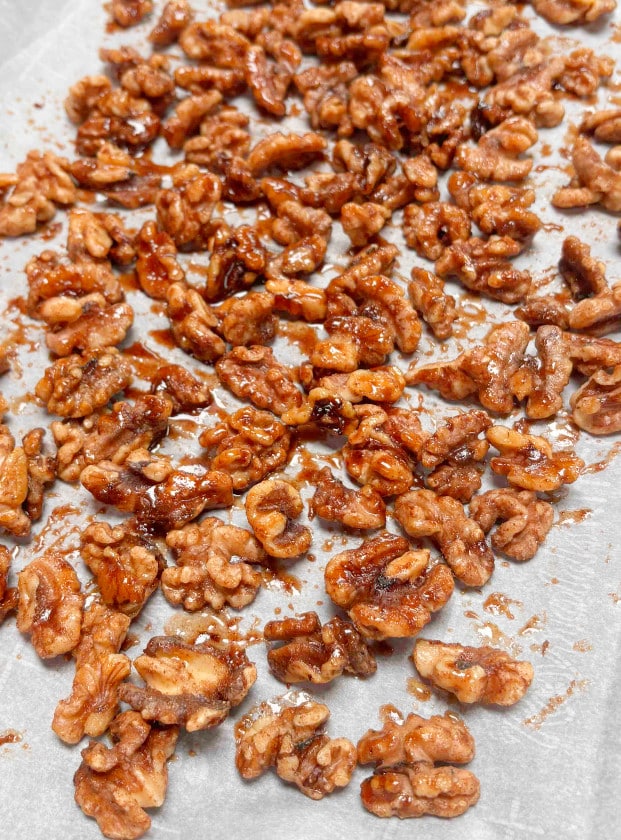 Spiced Walnuts cooling on a sheetpan lined with parchment paper