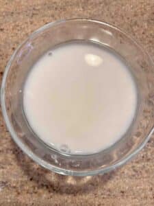 Cornstarch and water mixed in a small glass bowl on a counter.