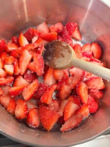 Strawberries and sugar in a sauce pan before cooking